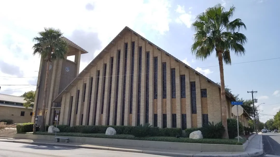 Mid-century modern A-frame church with rhythmic vertical windows and blonde brick in San Antonio Texas